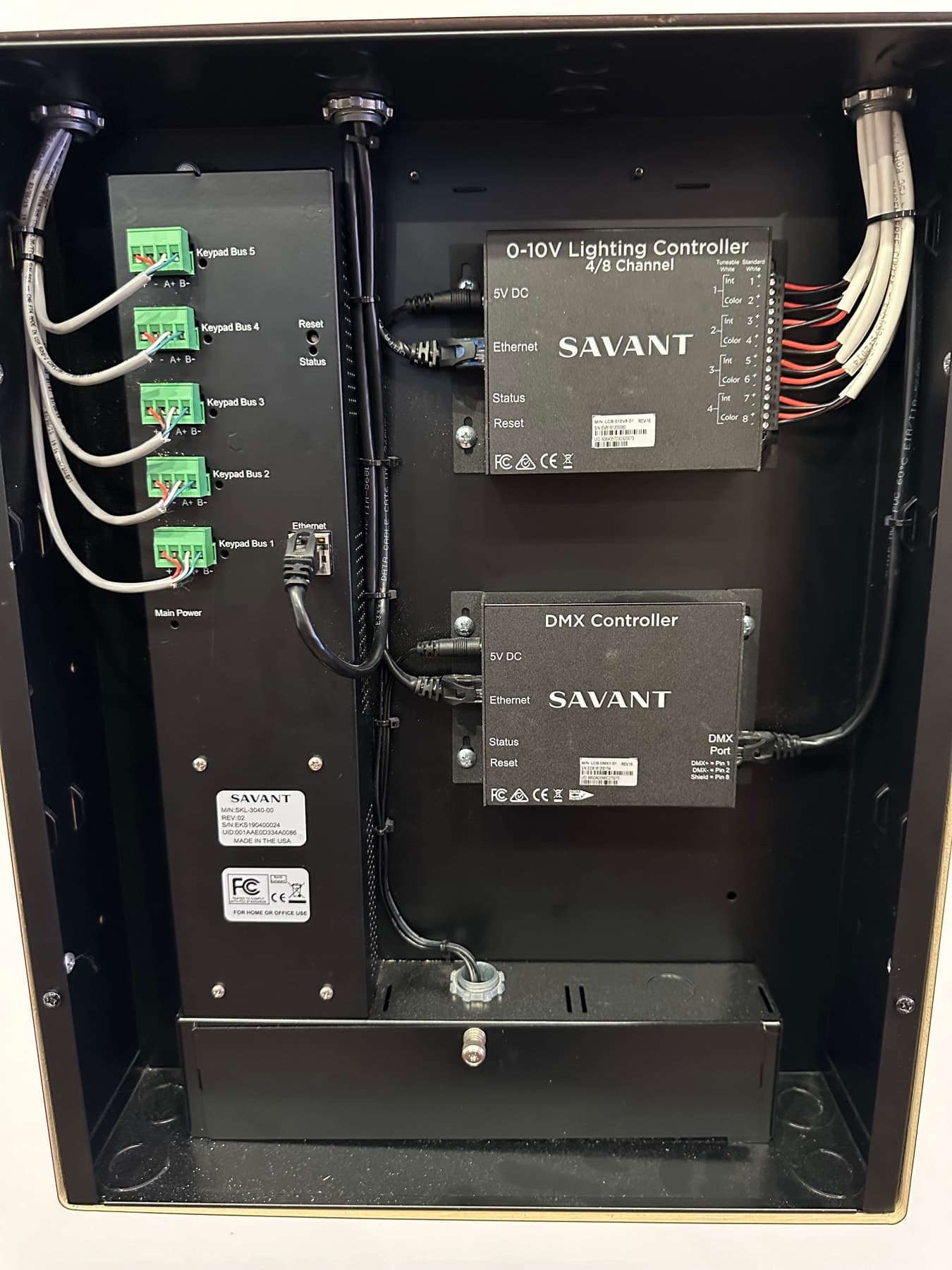 Lighting control enclosure with a 0-10V lighting controller, a DMX controller and keypad bus terminations